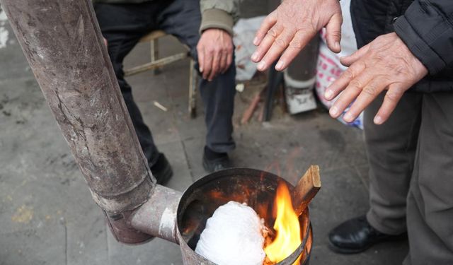 Pazarcılar tezgah başında sobayla ısınıyor